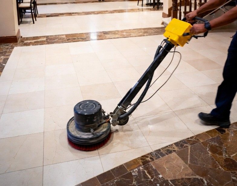 hotel lobby with glossy ceramic tile floors being cleaned by professional floor machine at night
